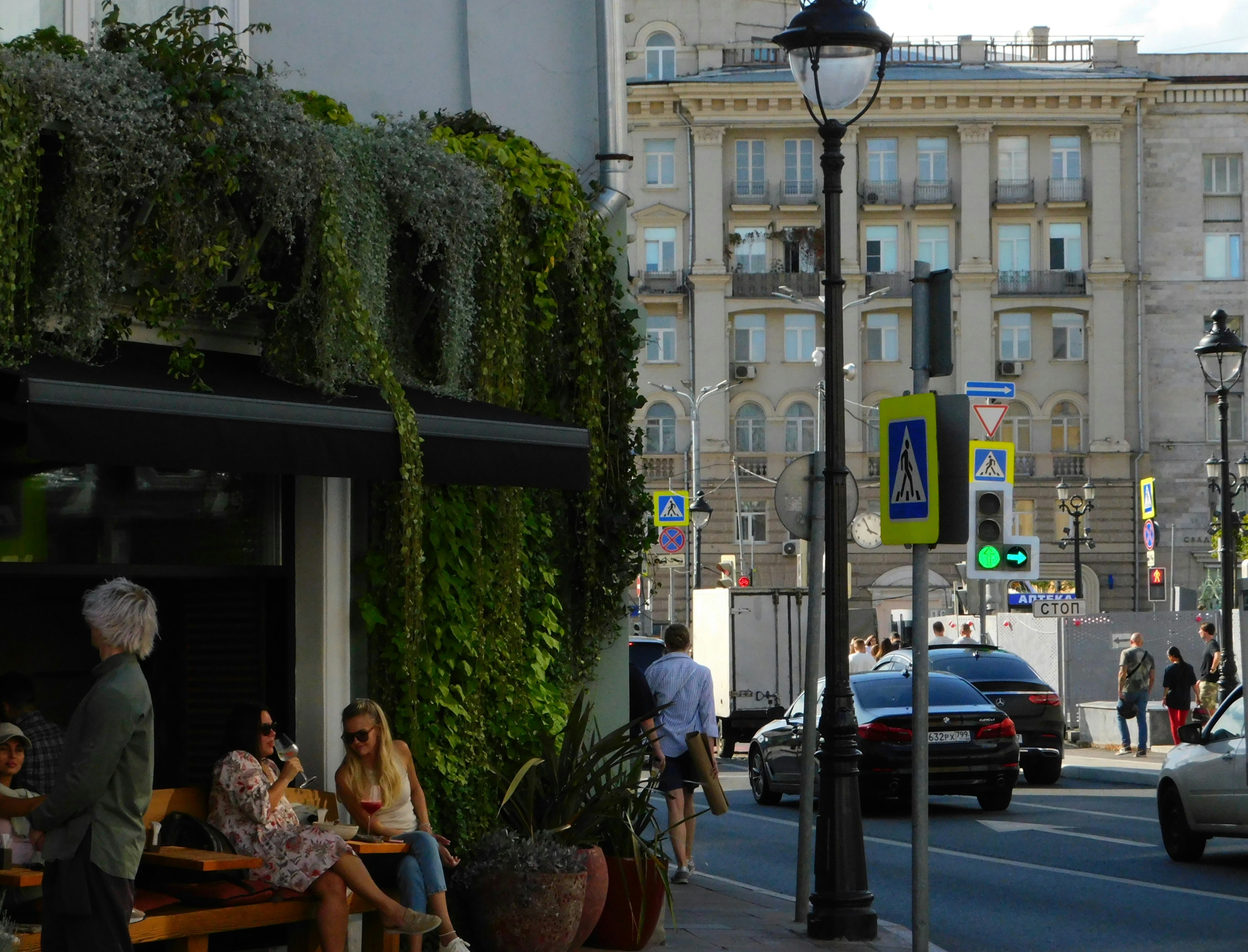 People relax outside a cafe in a city.