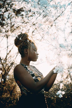 Woman admires blossoming flowers in the sunlight.