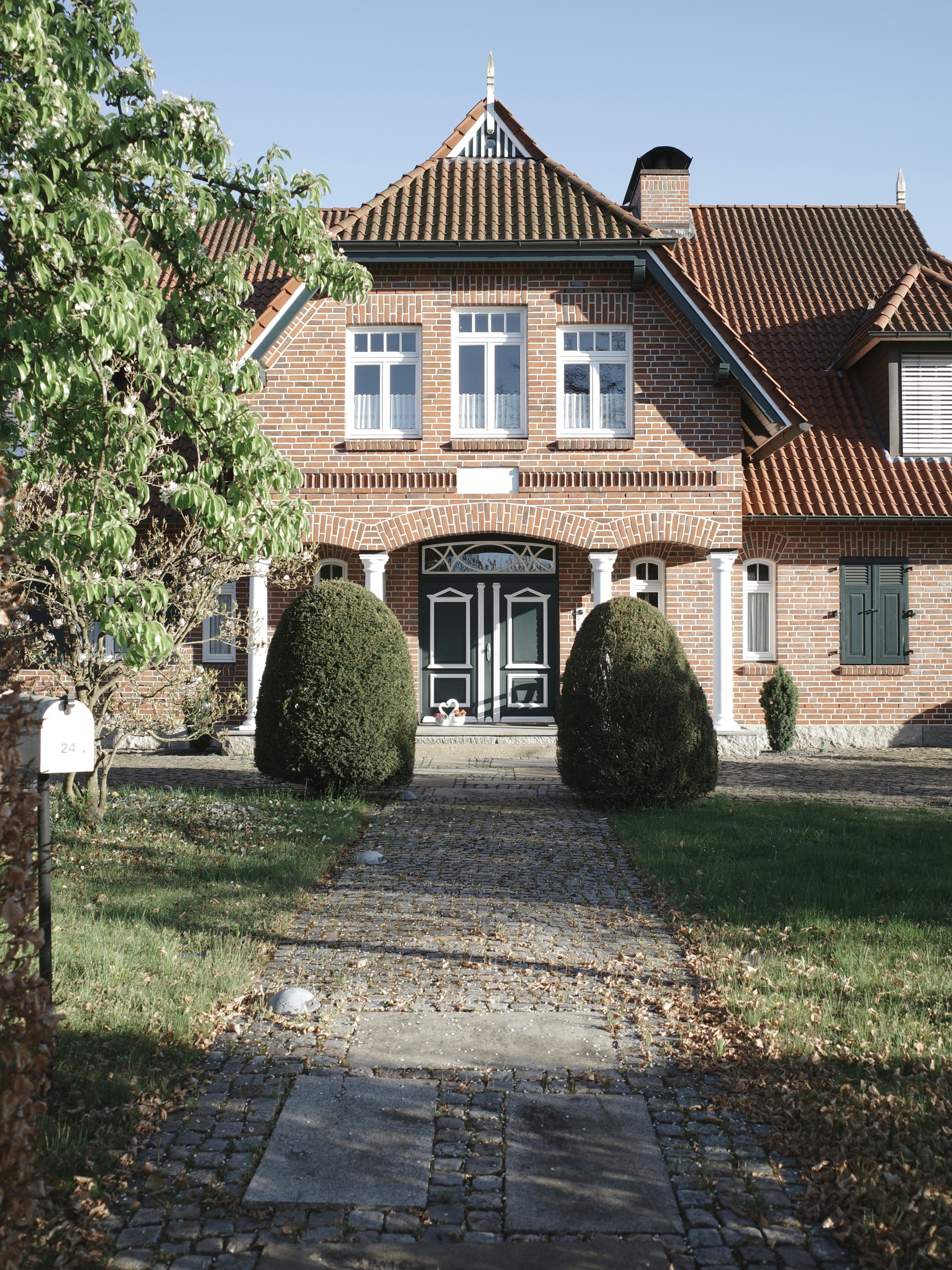 Uma casa de tijolos com um charmoso jardim da frente.