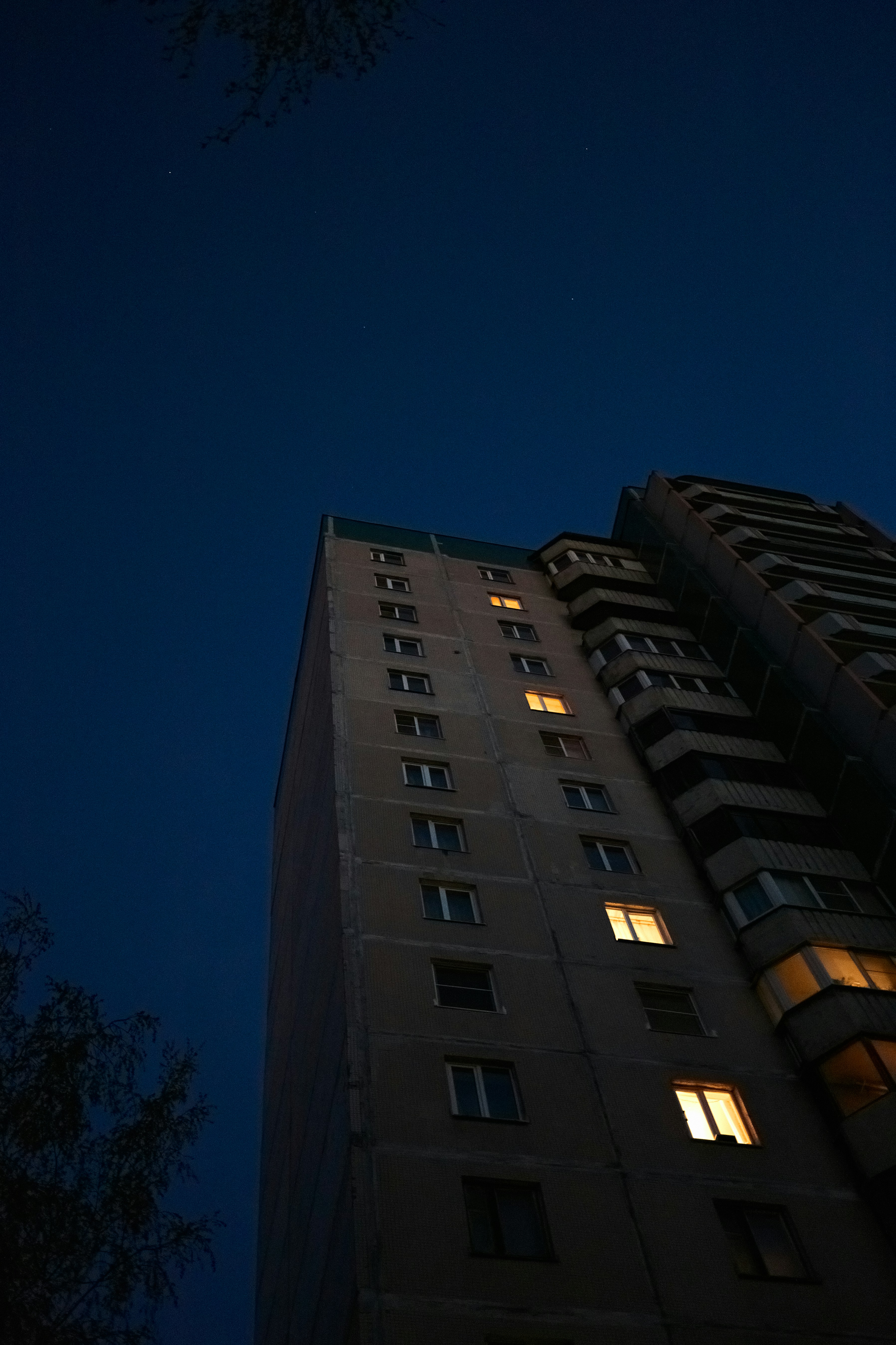 Apartment building at night with glowing lights.