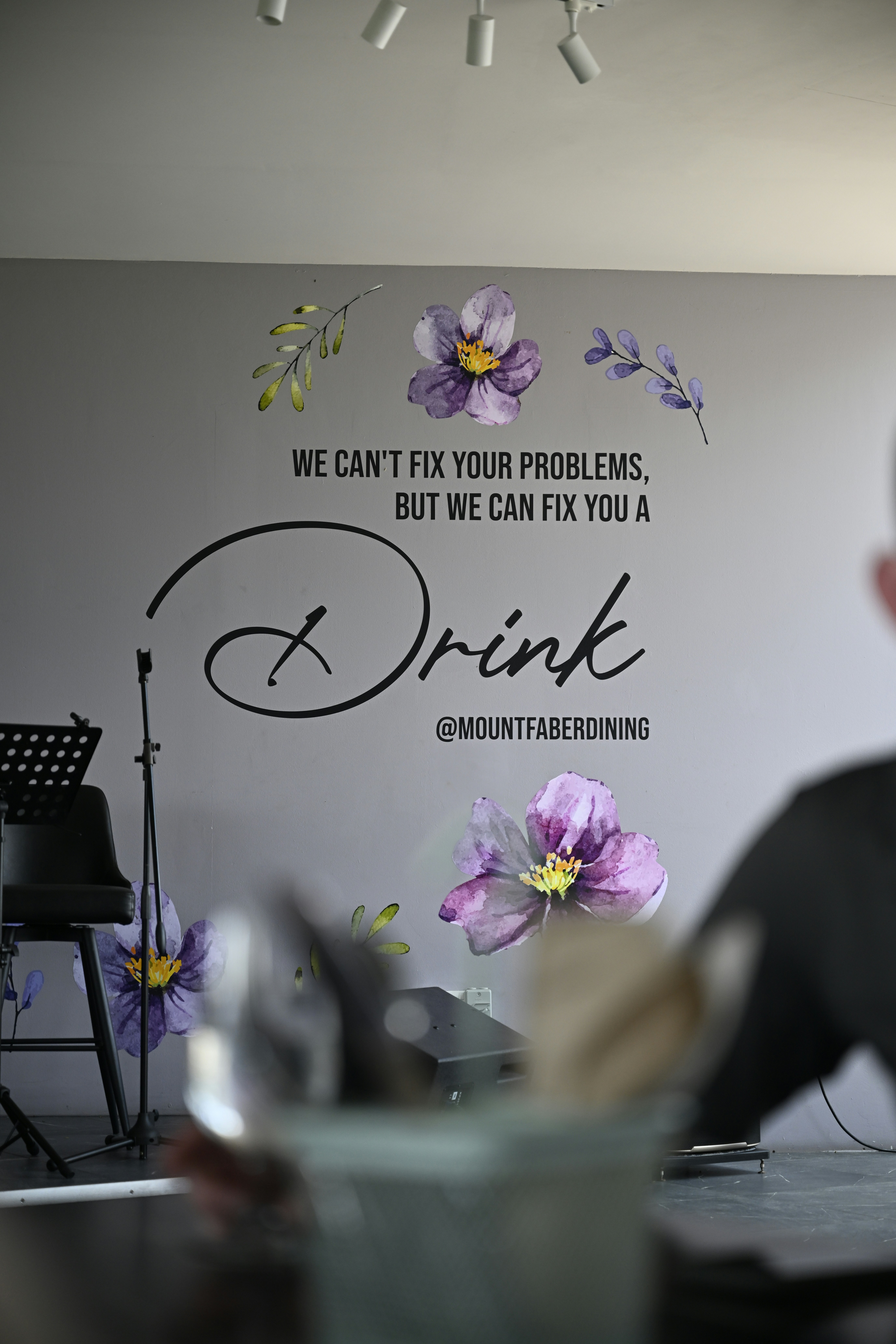 A wall with floral decor invites a drink.