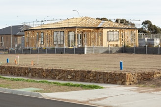 A house under construction sits on a vacant lot.