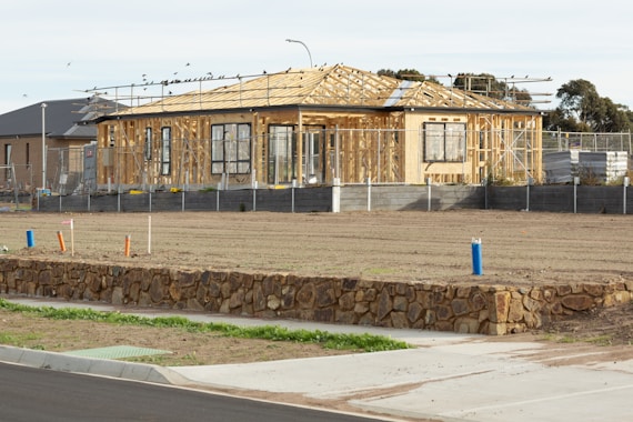 A house under construction sits on a vacant lot.