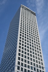 Tall modern skyscraper reaching up into the blue sky.