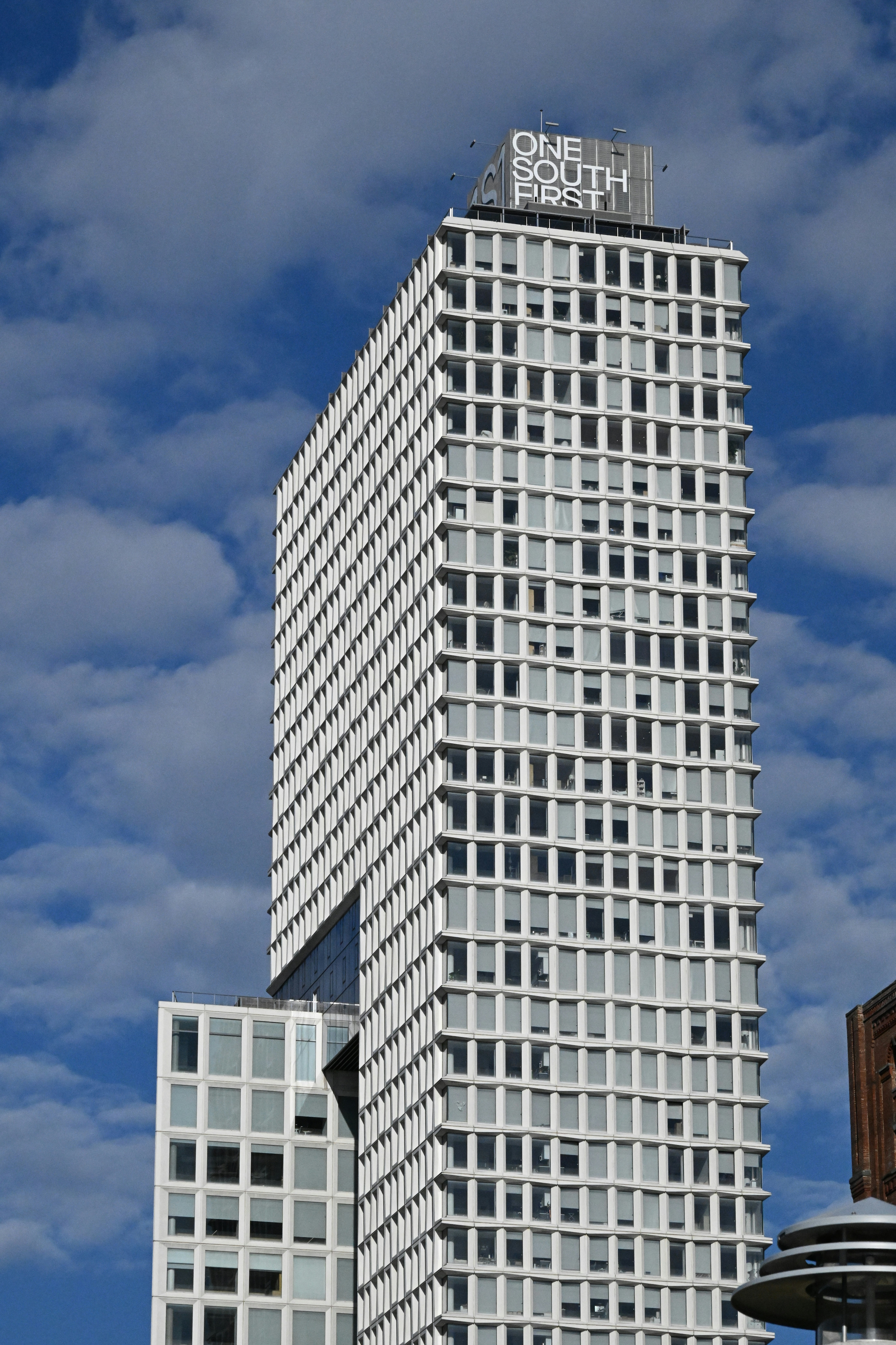 A tall white building under a cloudy sky.