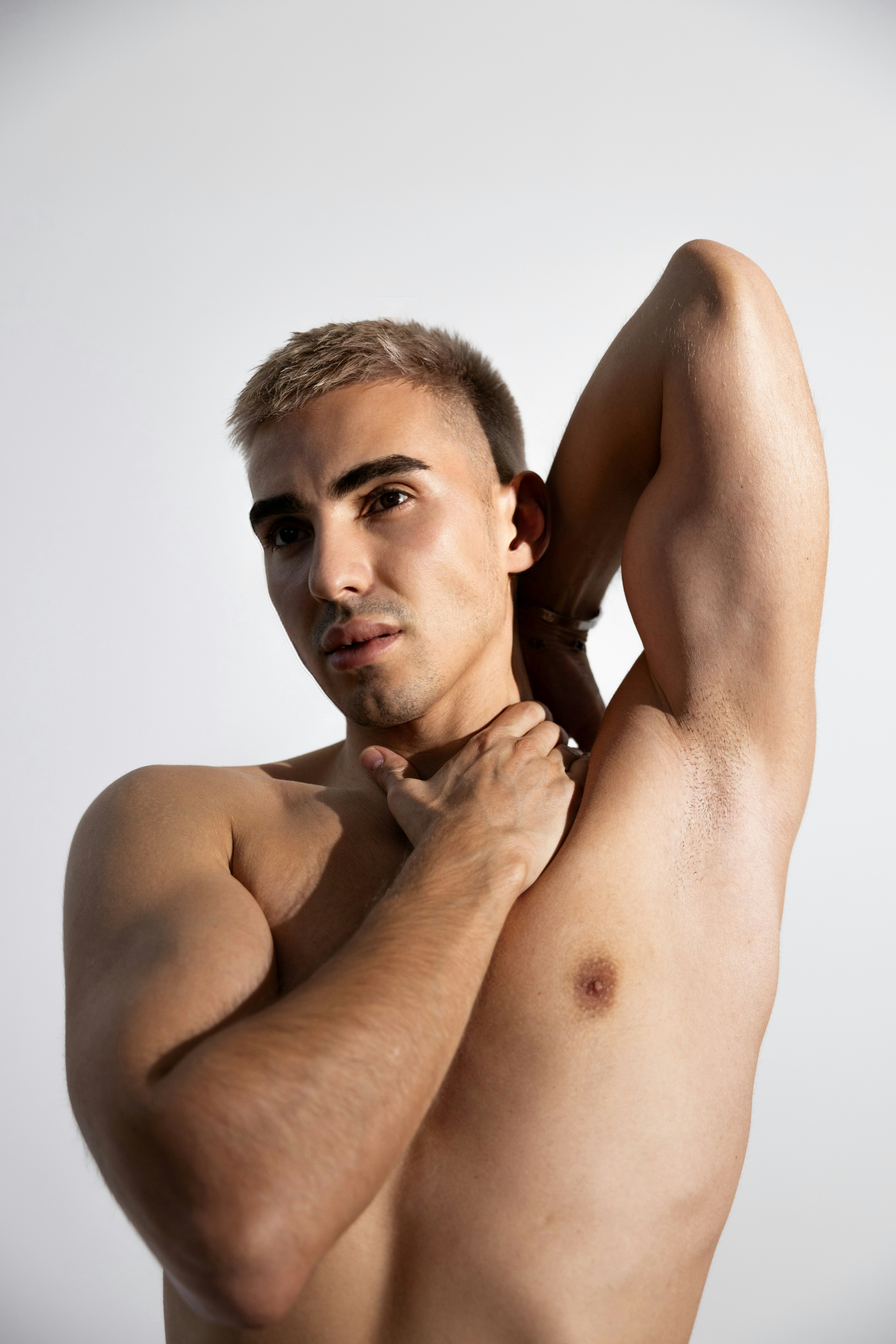 A muscular man stretches and poses for the camera