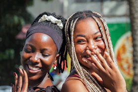 Two smiling women are close together outdoors