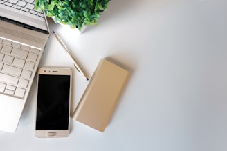 Laptop and phone on a clean, white surface.