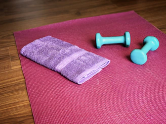 Yoga mat, weights, and a towel ready for a workout.