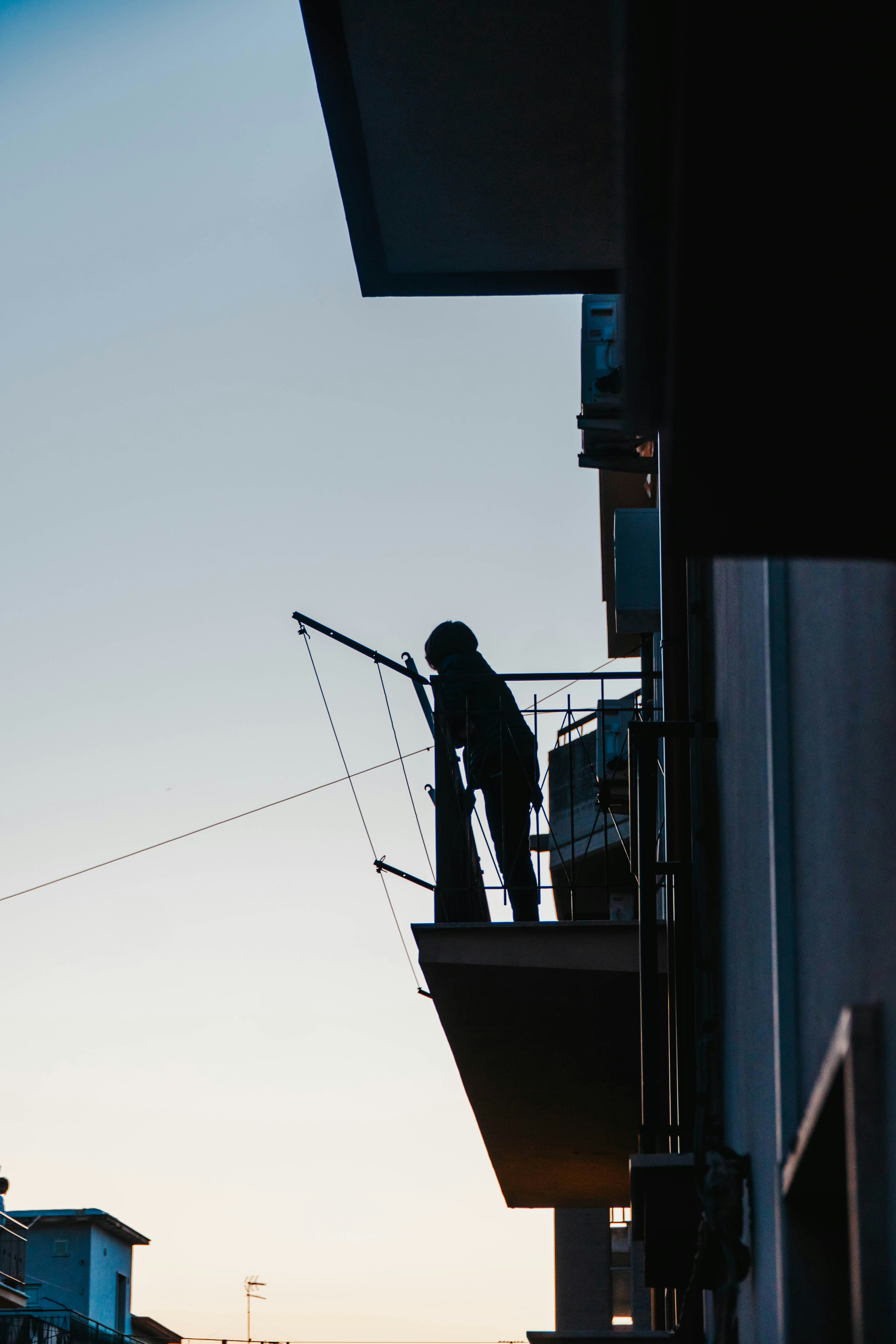 A silhouette of a person on a balcony.