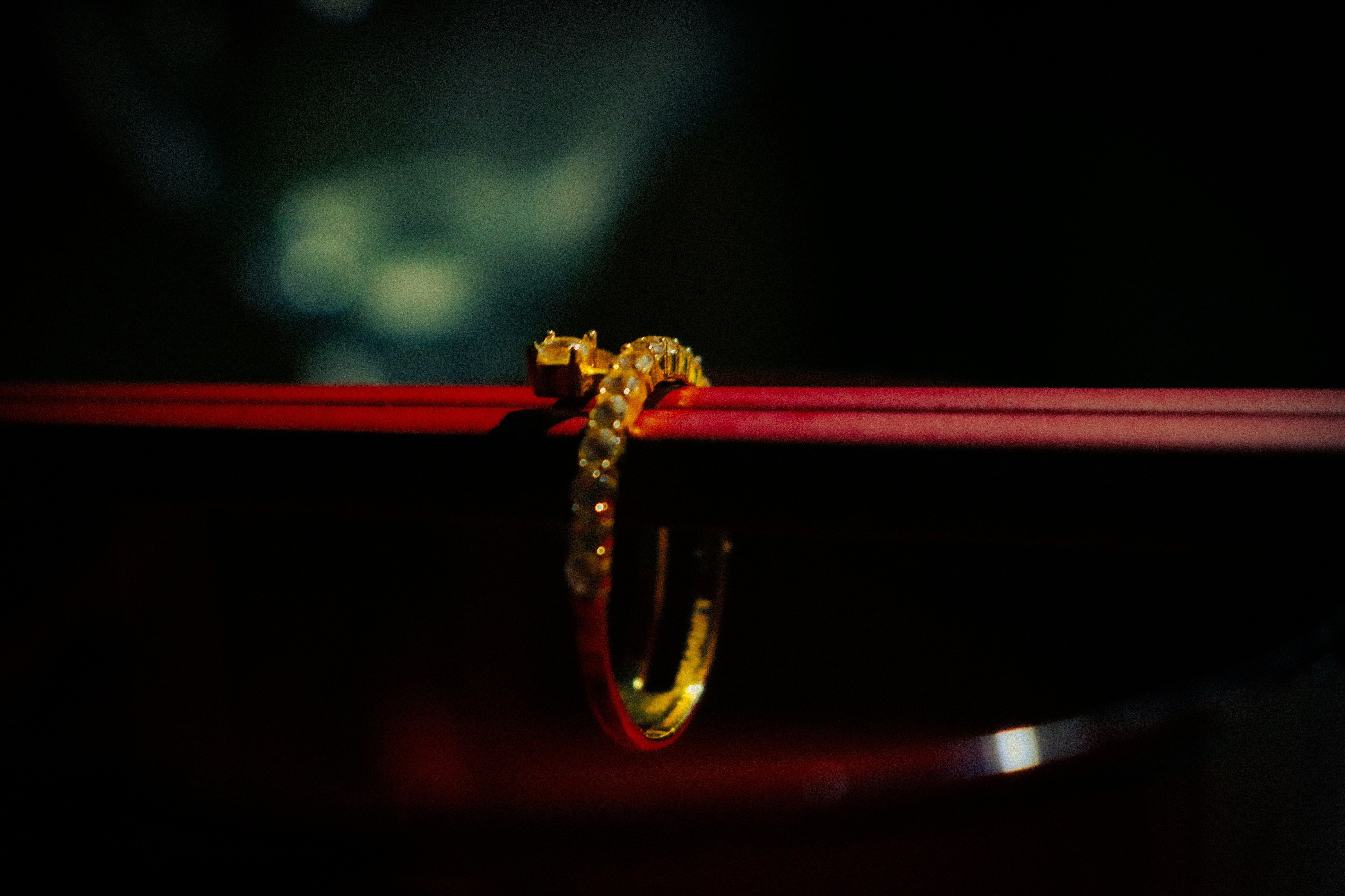 Gold ring resting on red chopsticks.