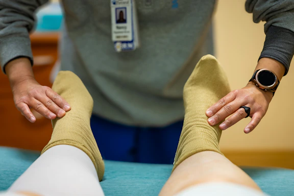 A healthcare worker examines a patient's feet.