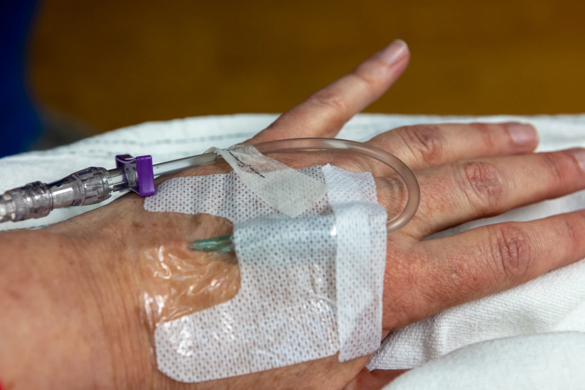IV drip in a patient's hand, representing MedBridge Transport's dialysis and infusion transportation