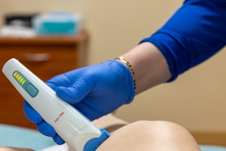 A medical professional using a laser device on a patient.