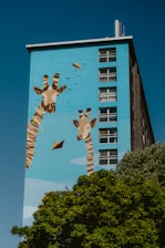 Giraffe mural adorns the side of a building.