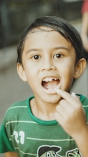 A boy shows off his missing tooth.