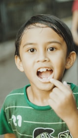 A boy shows off his missing tooth.