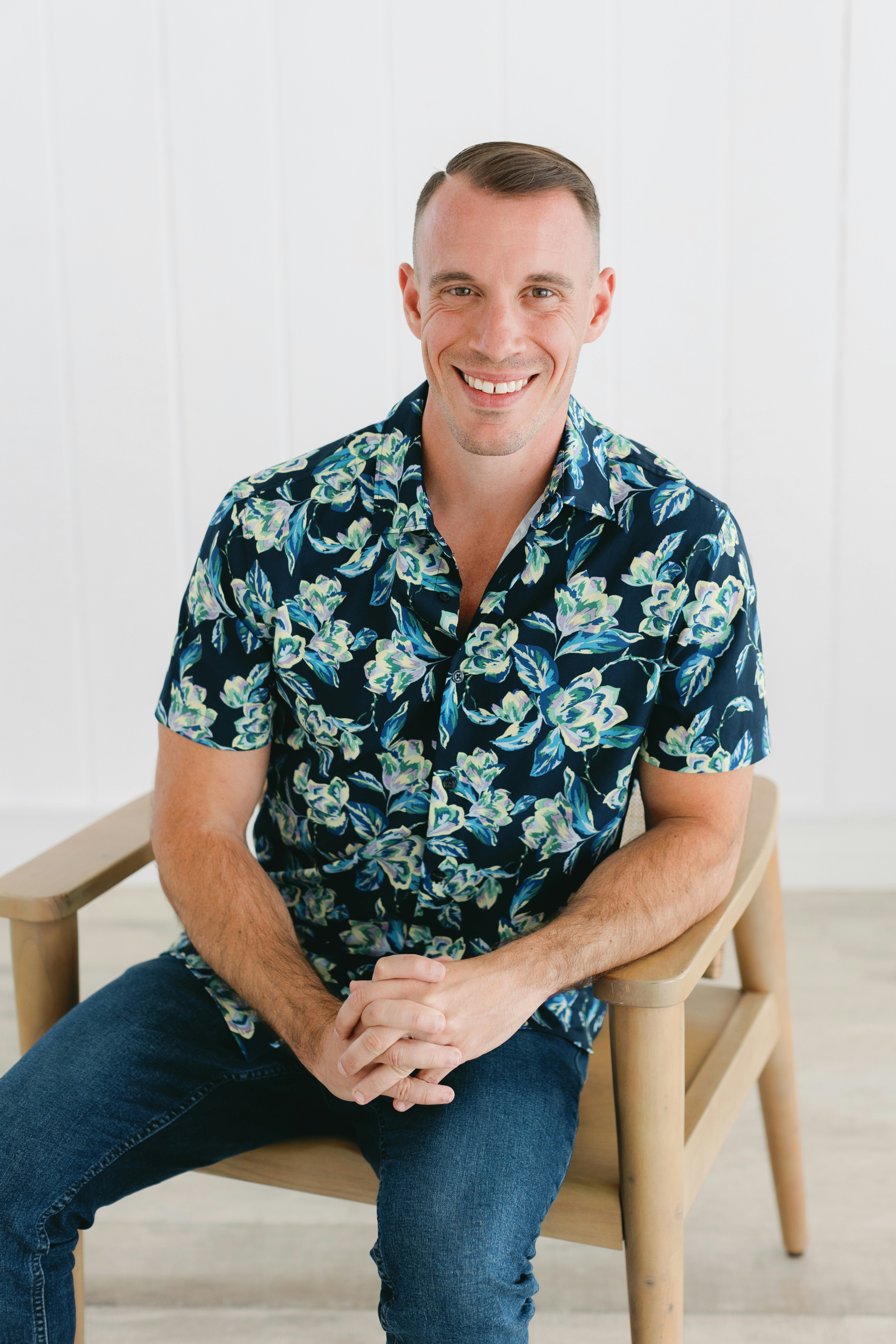 L’homme souriant est assis sur une chaise.