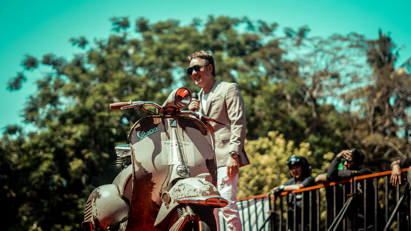 Rider standing with his vintage Vespa scooter