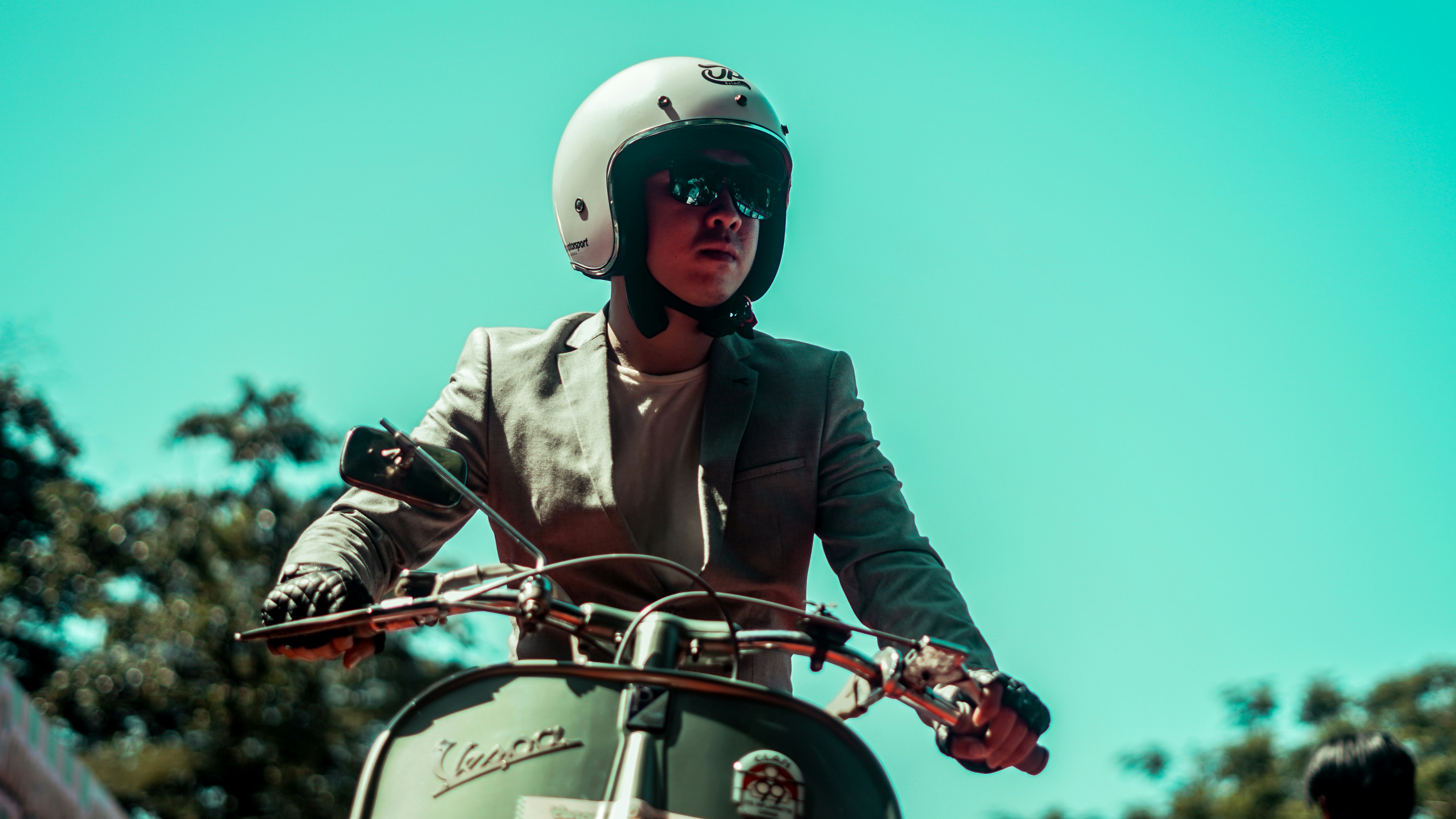 A stylish person is riding a scooter.