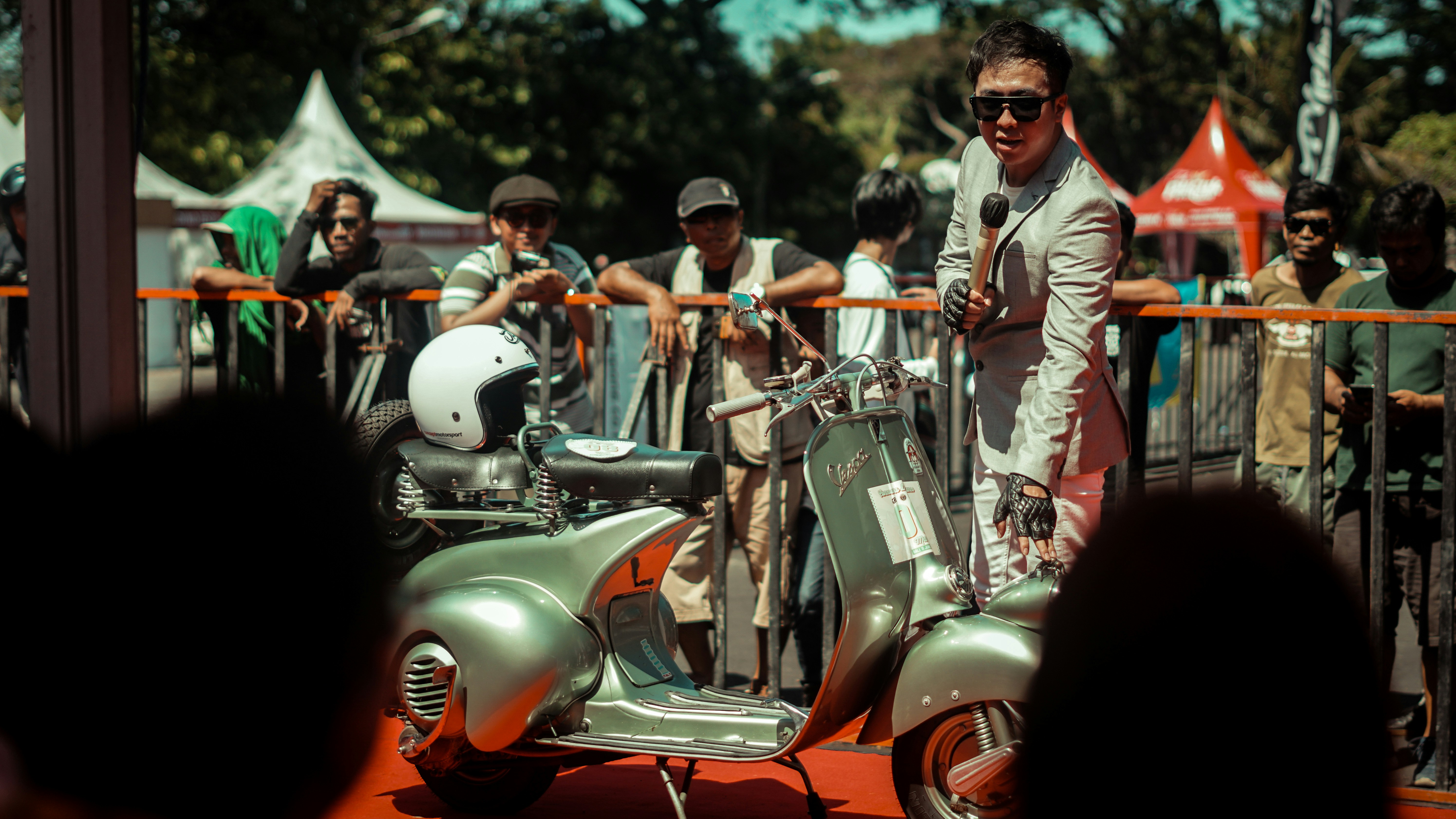 A man speaks at a scooter event.