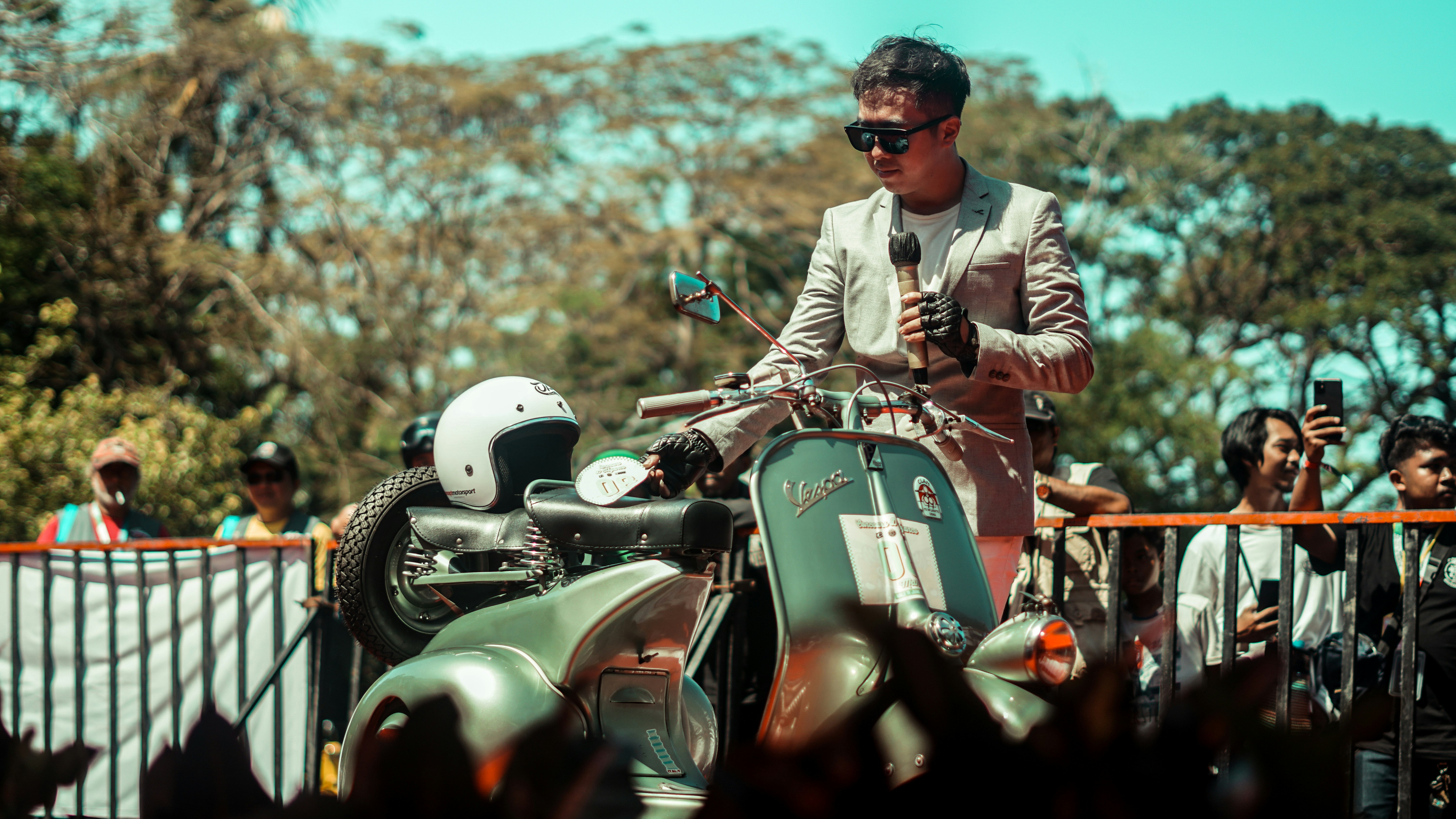A man admires a vintage scooter at an event.