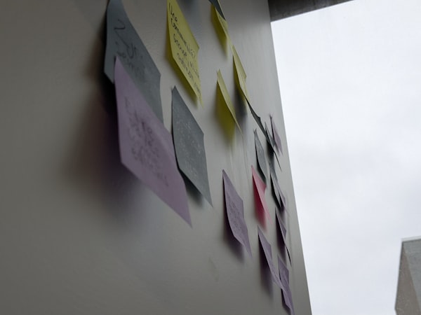 Notities en stickers gegroepeerd op een wand.