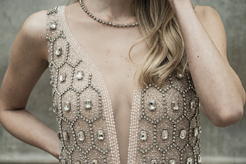 A woman is wearing a sparkling, jeweled dress.