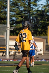 A lacrosse player walks on the field.