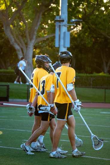 Lacrosse players walk across the field together.