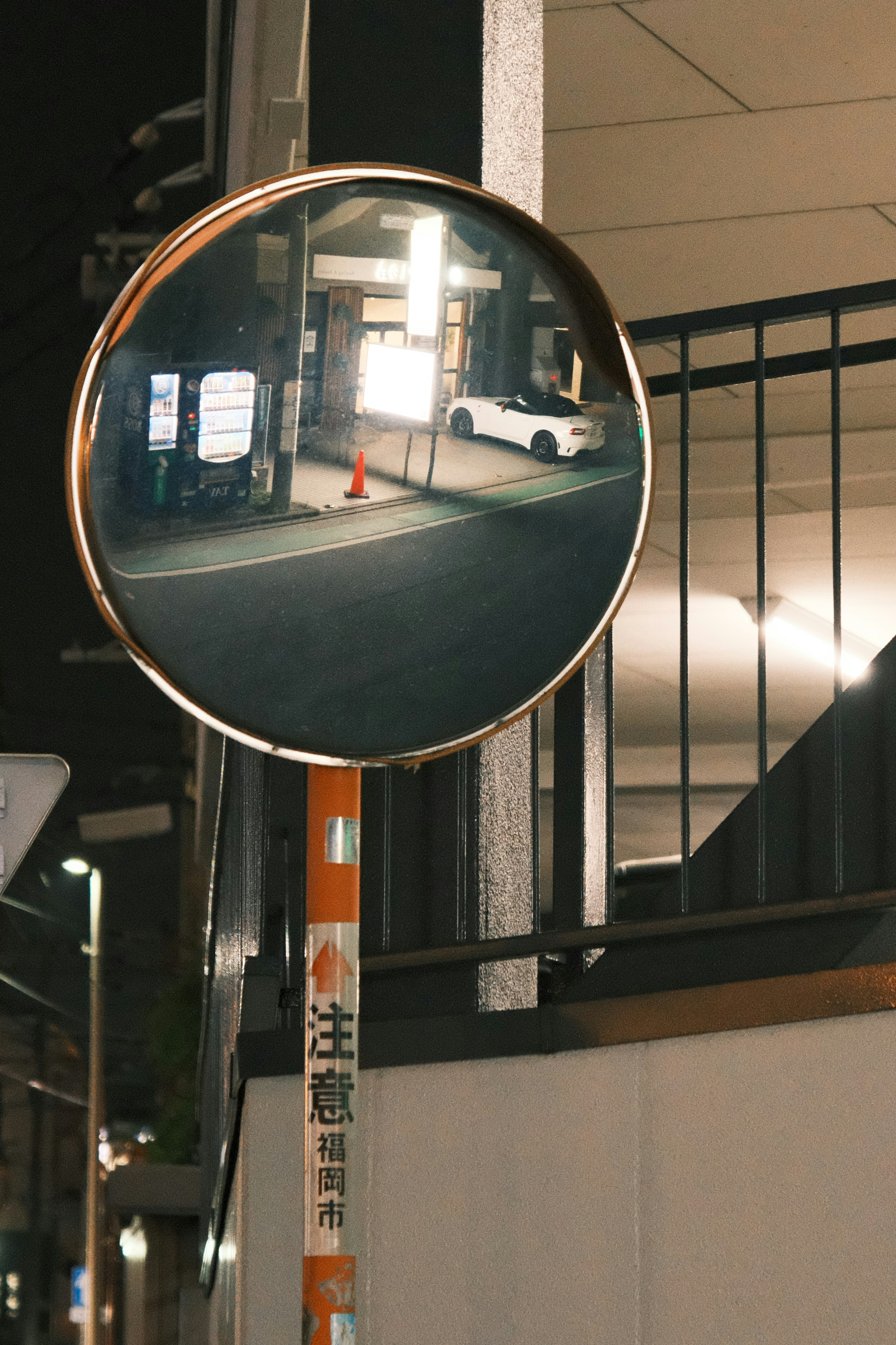 A car is reflected in a circular mirror.
