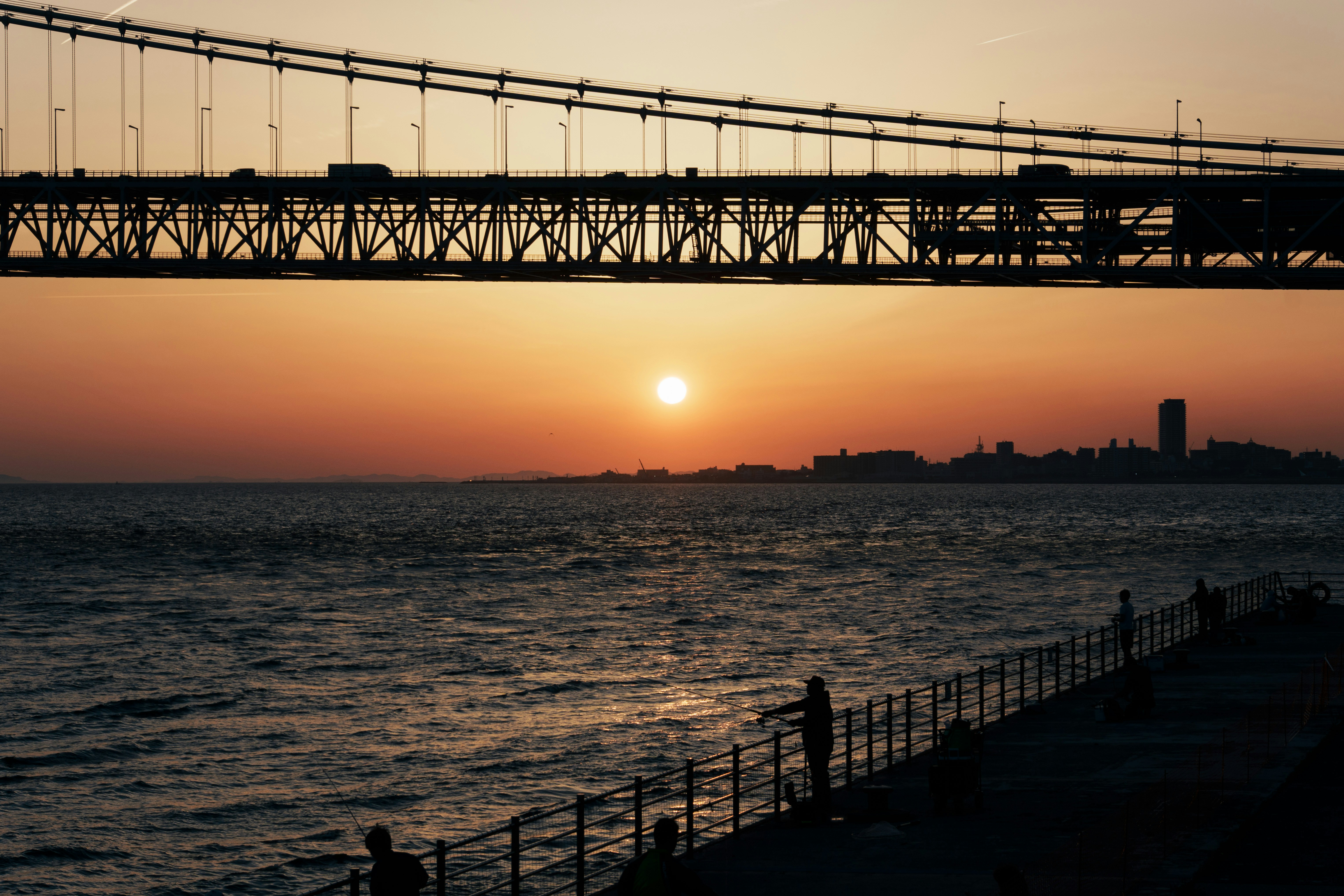 Tramonto sull'acqua con un ponte.