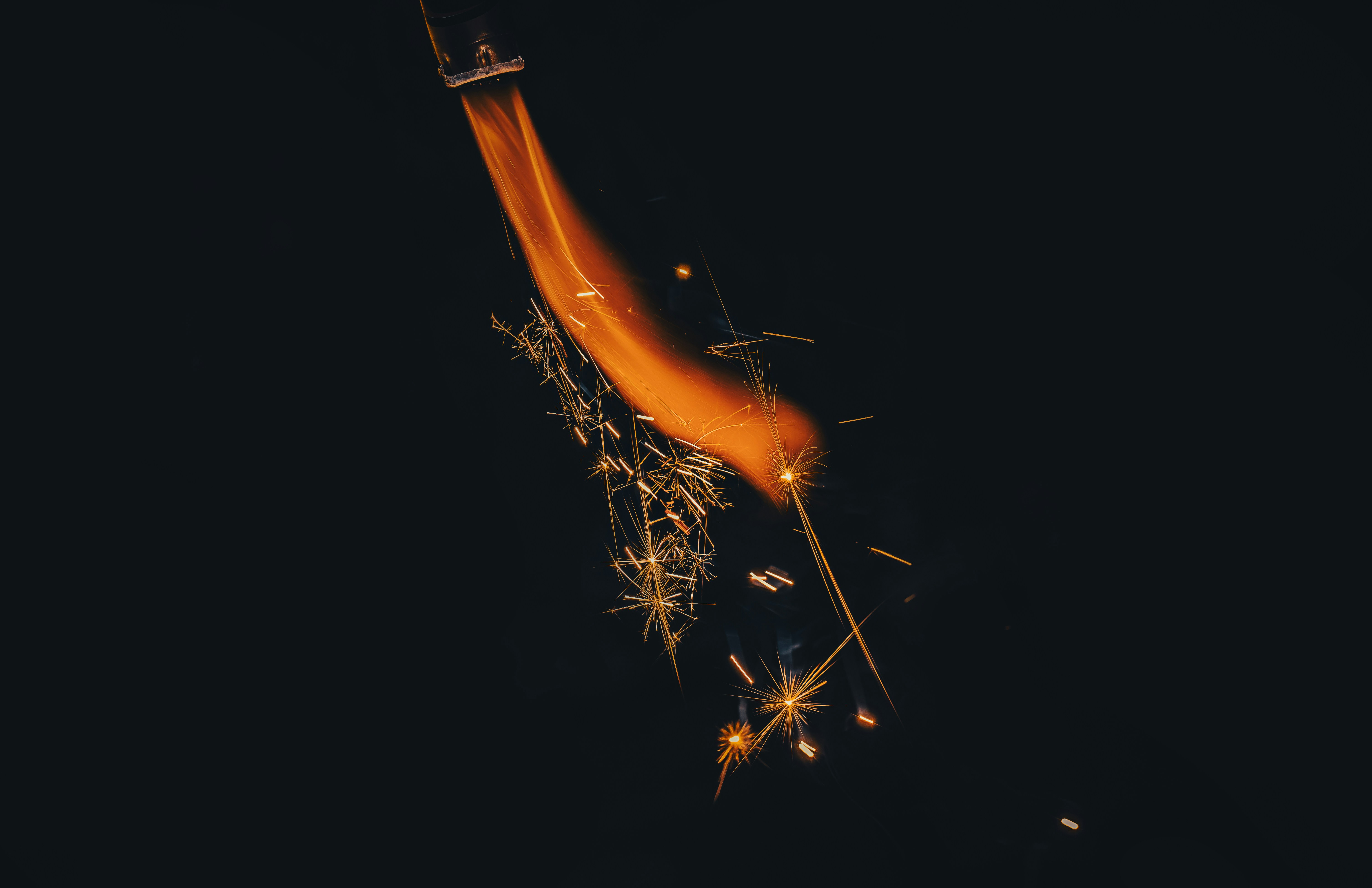 Sparks and fire dance against a dark background.