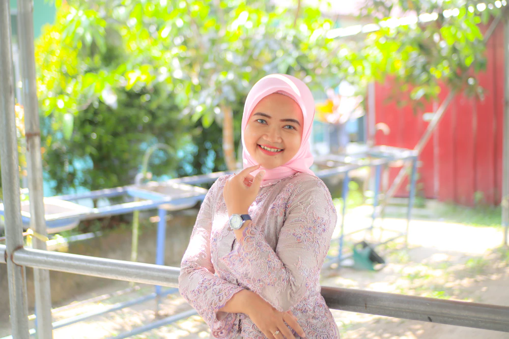 A woman in a pink hijab standing outdoors
