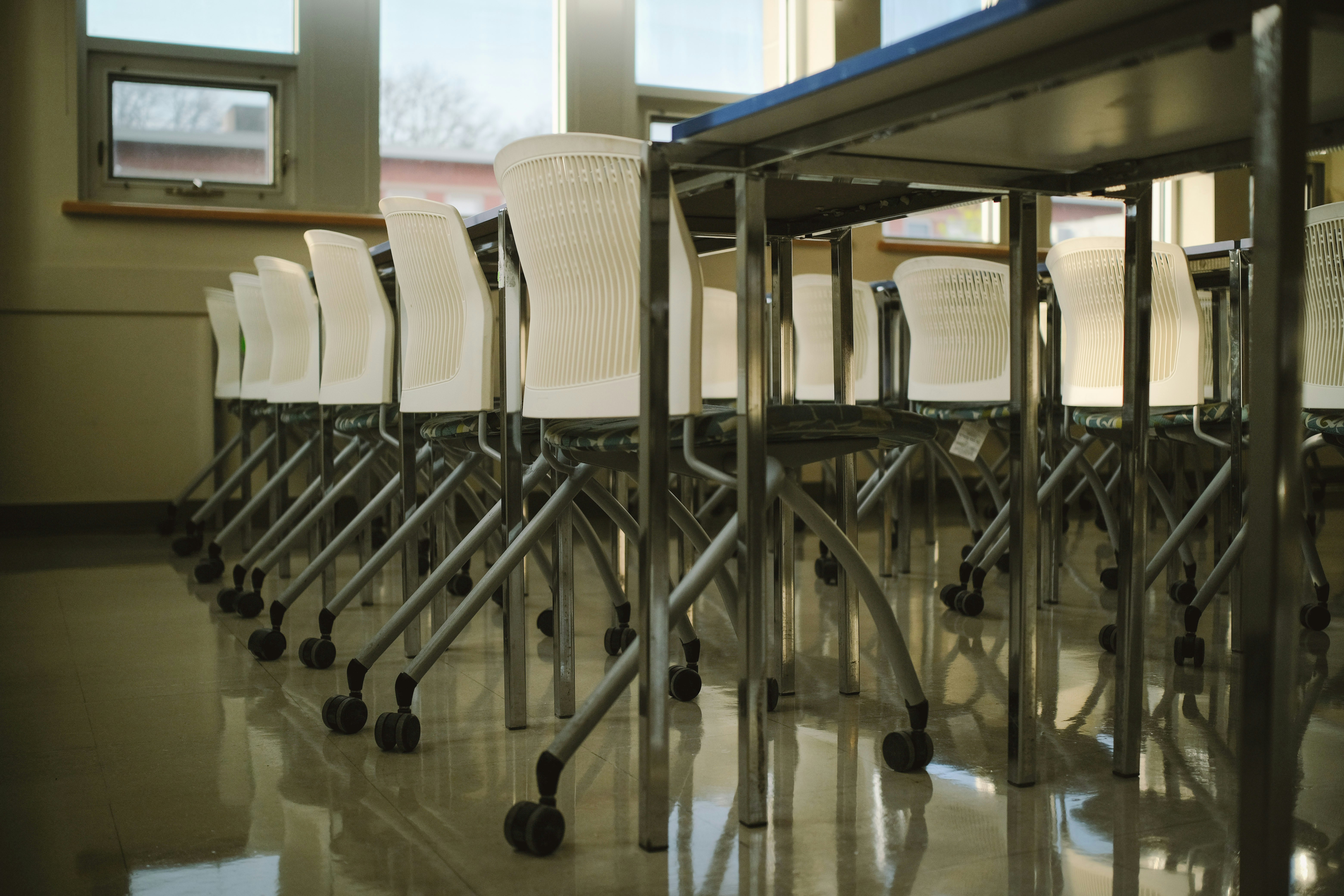 Empty classroom with chairs under tables