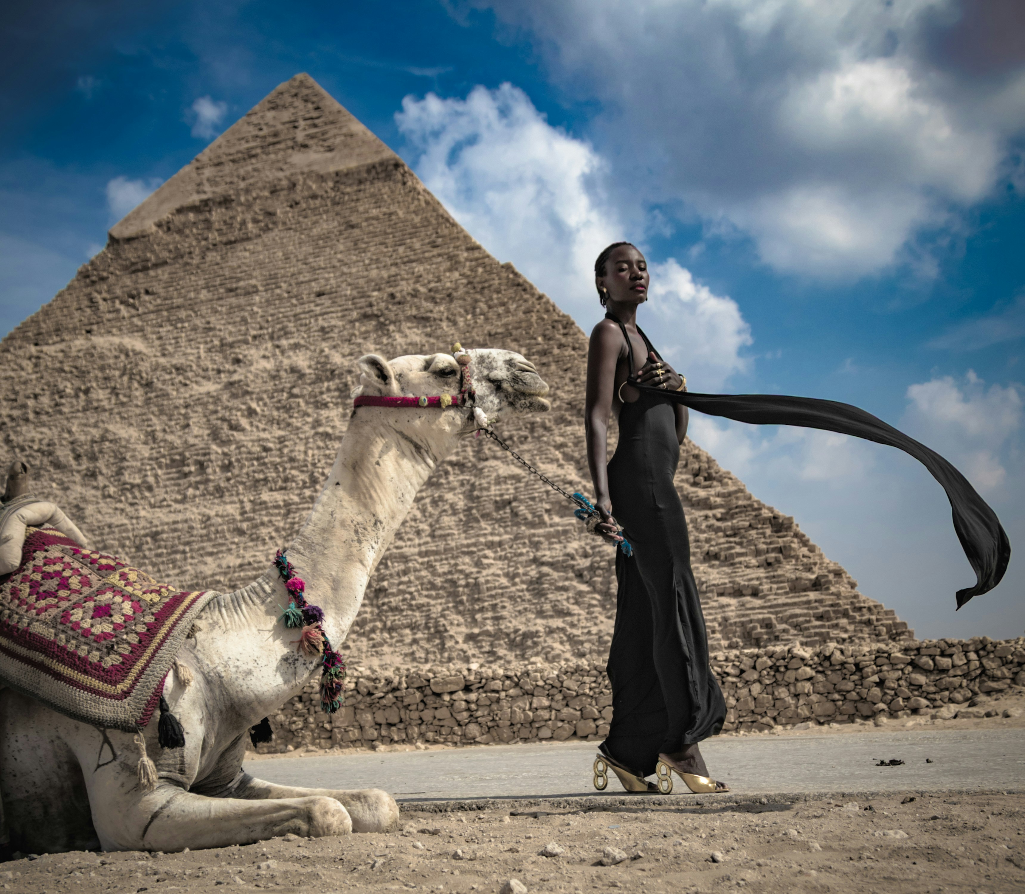 Woman and camel pose near the great pyramid.