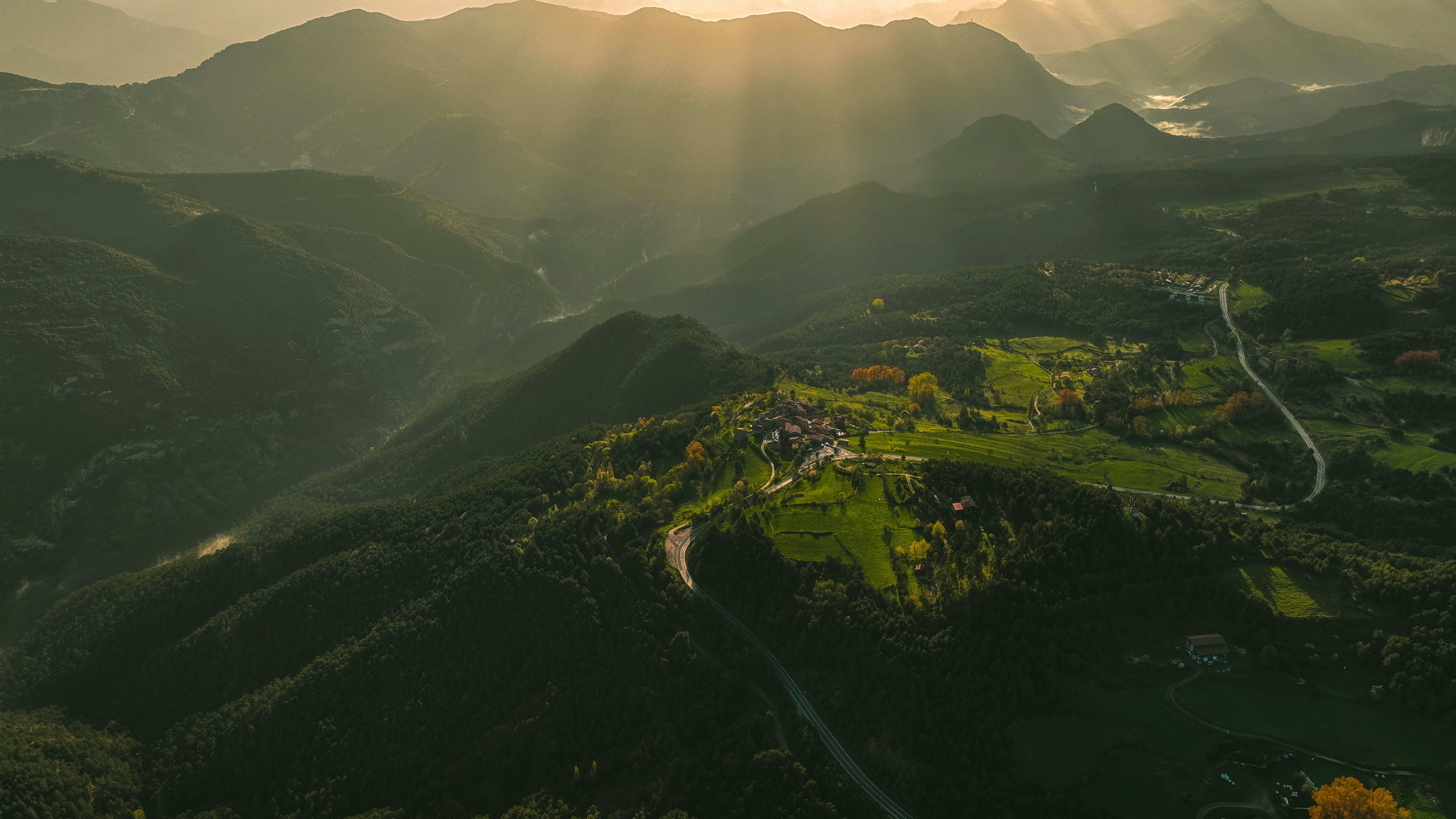 La luce del sole splende su un paesaggio montuoso.
