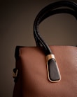A brown and black handbag is on display.