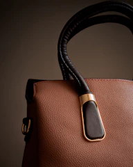 A brown and black handbag is on display.