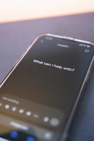 Phone screen asks: "what can i help with?"