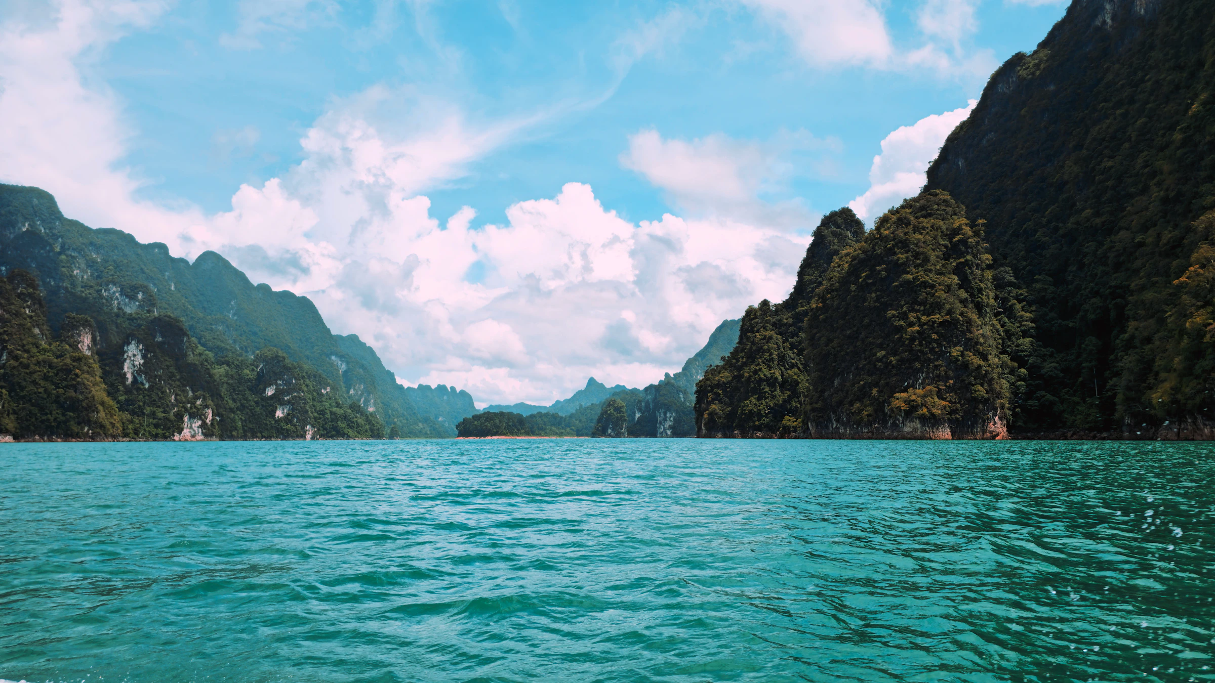 Lush limestone mountains surrounding a turquoise lake