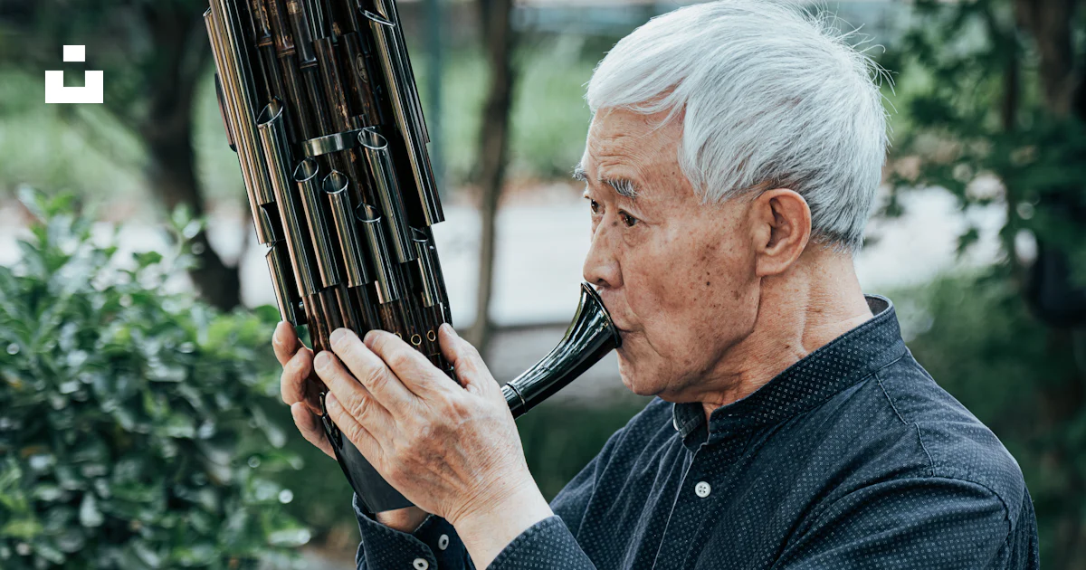 An older man plays a traditional chinese musical instrument. photo ...