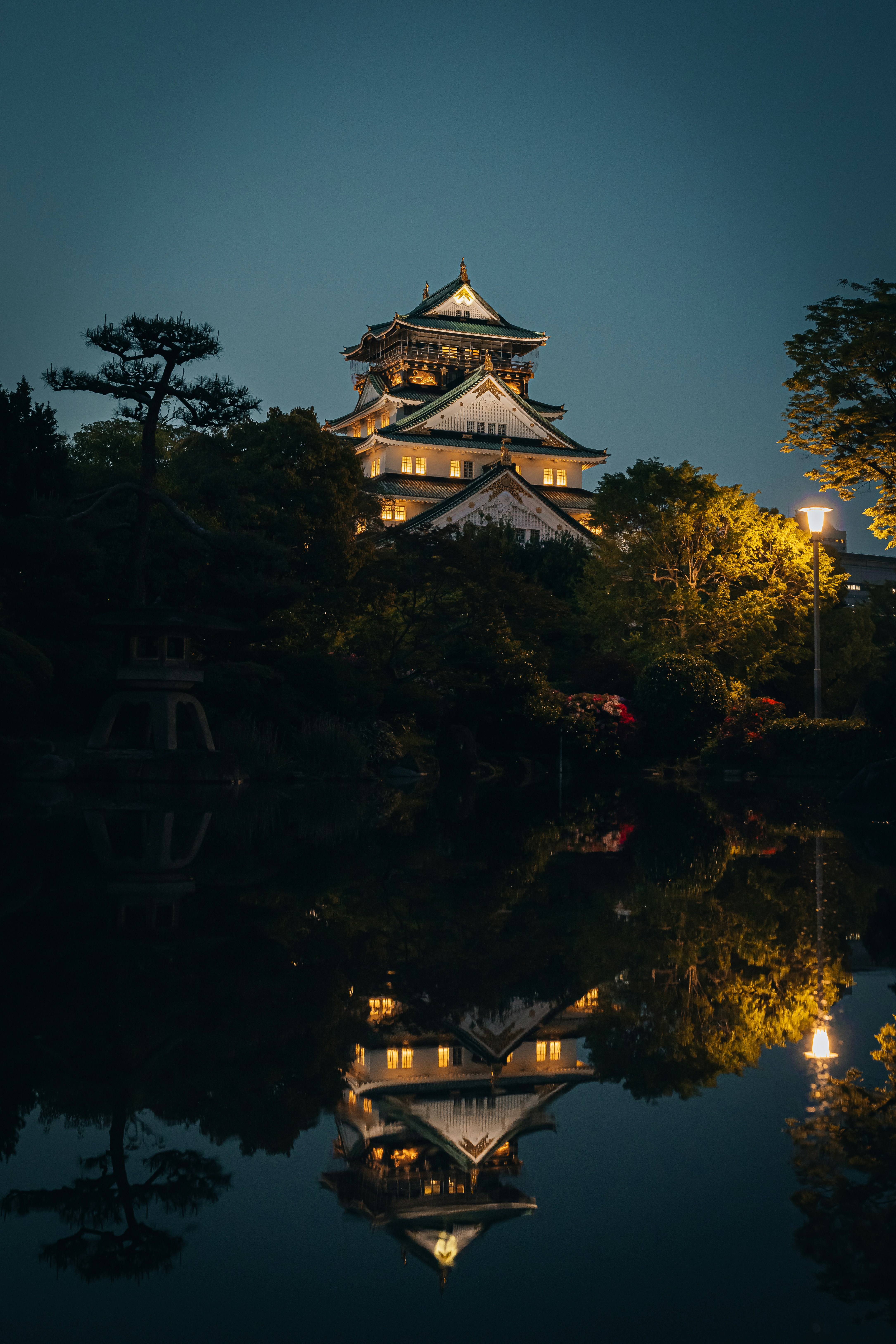 Osaka castle is beautifully reflected in the dark water.