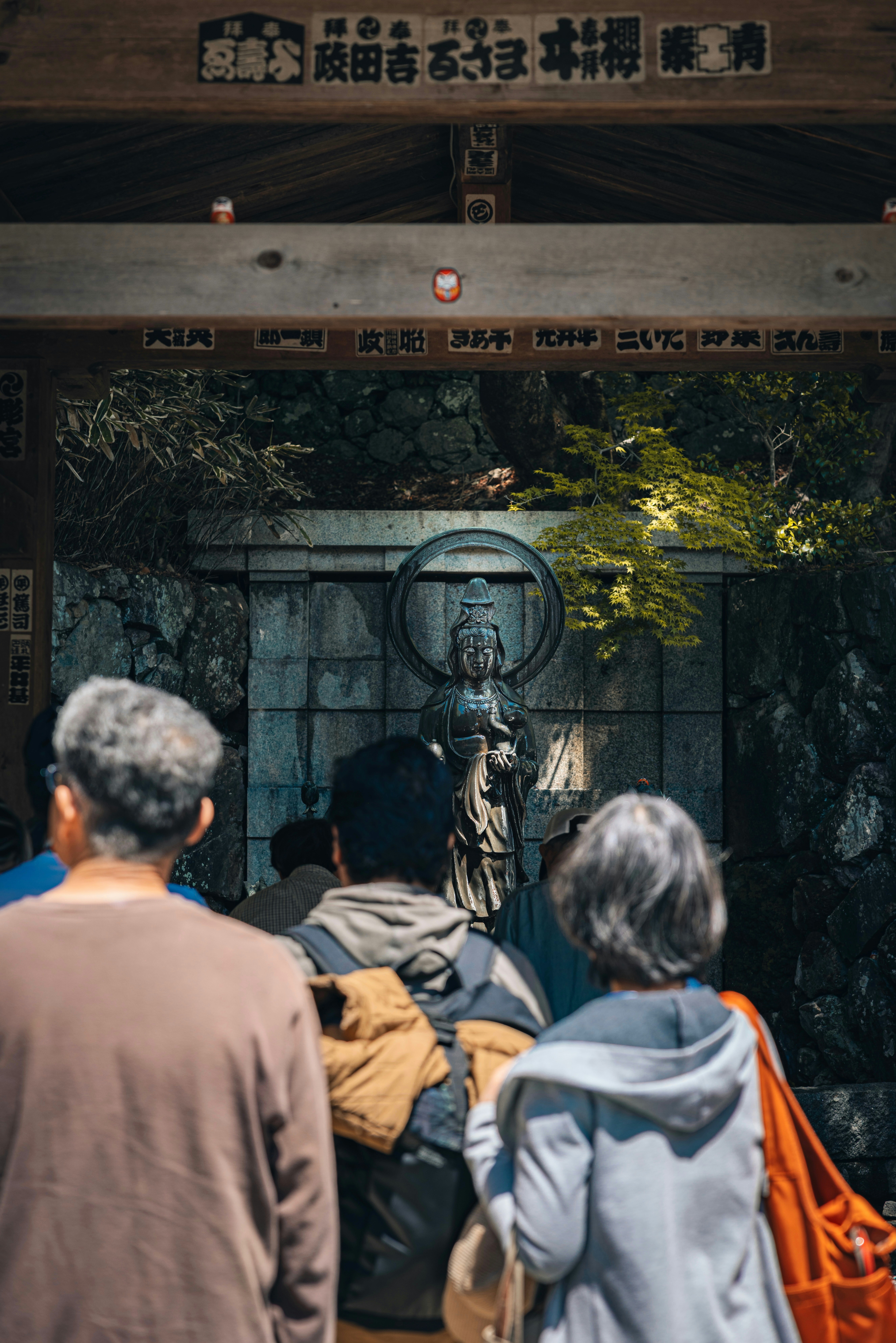 People are looking at a buddha statue.