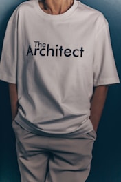 Someone wears a white "the architect" t-shirt.