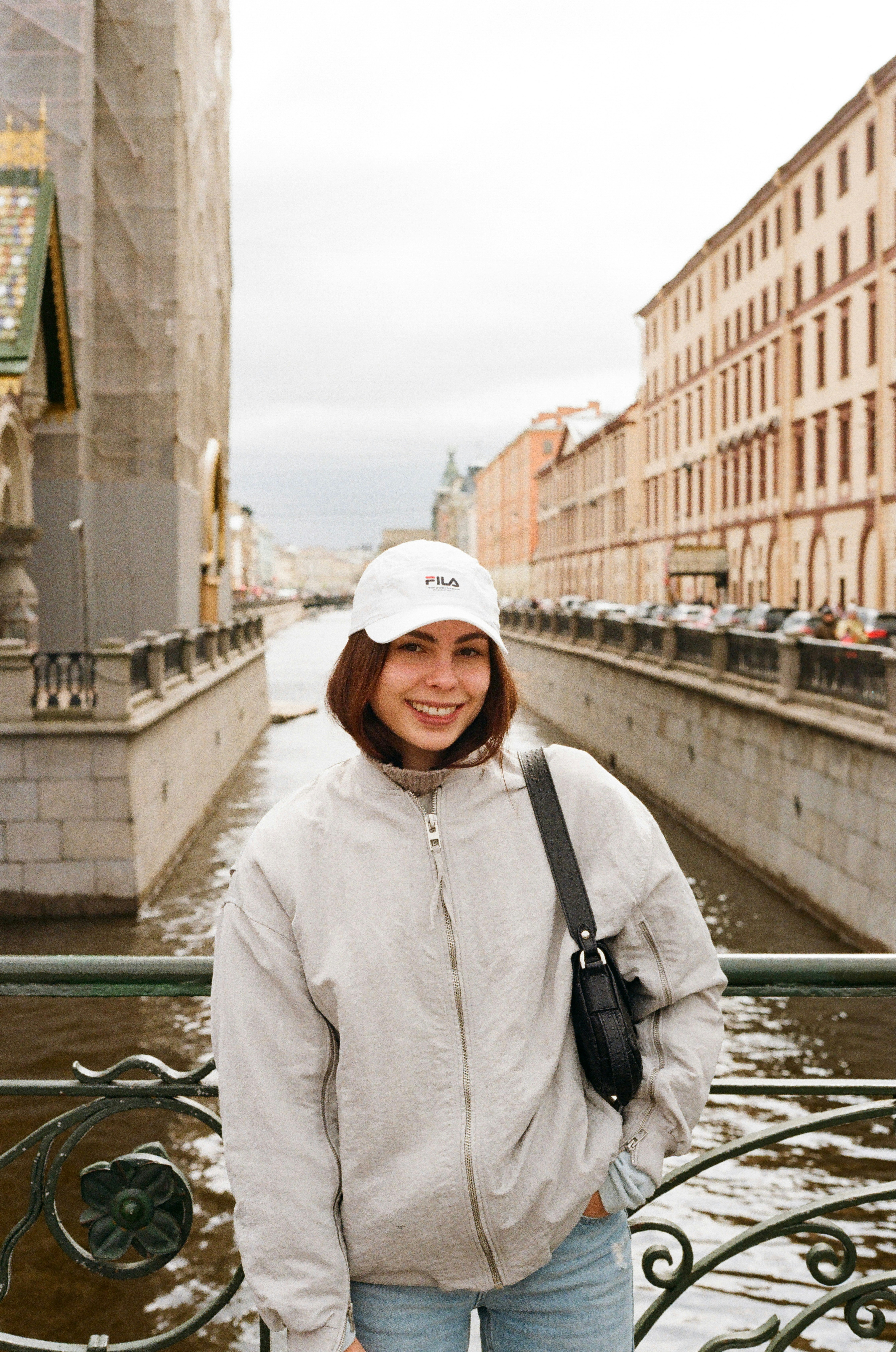 Woman smiles while posing on a bridge.