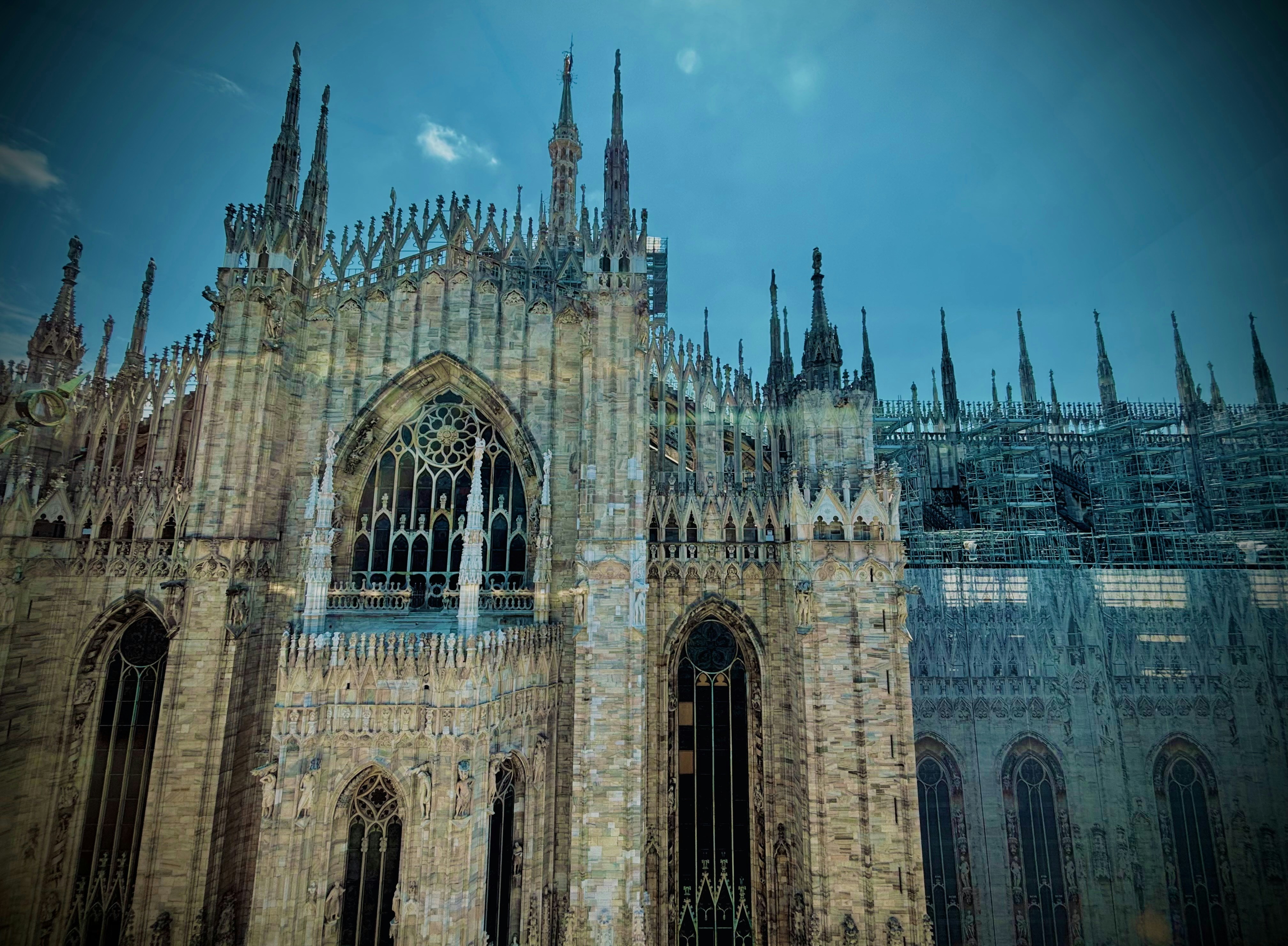 The milan cathedral stands tall against the blue sky
