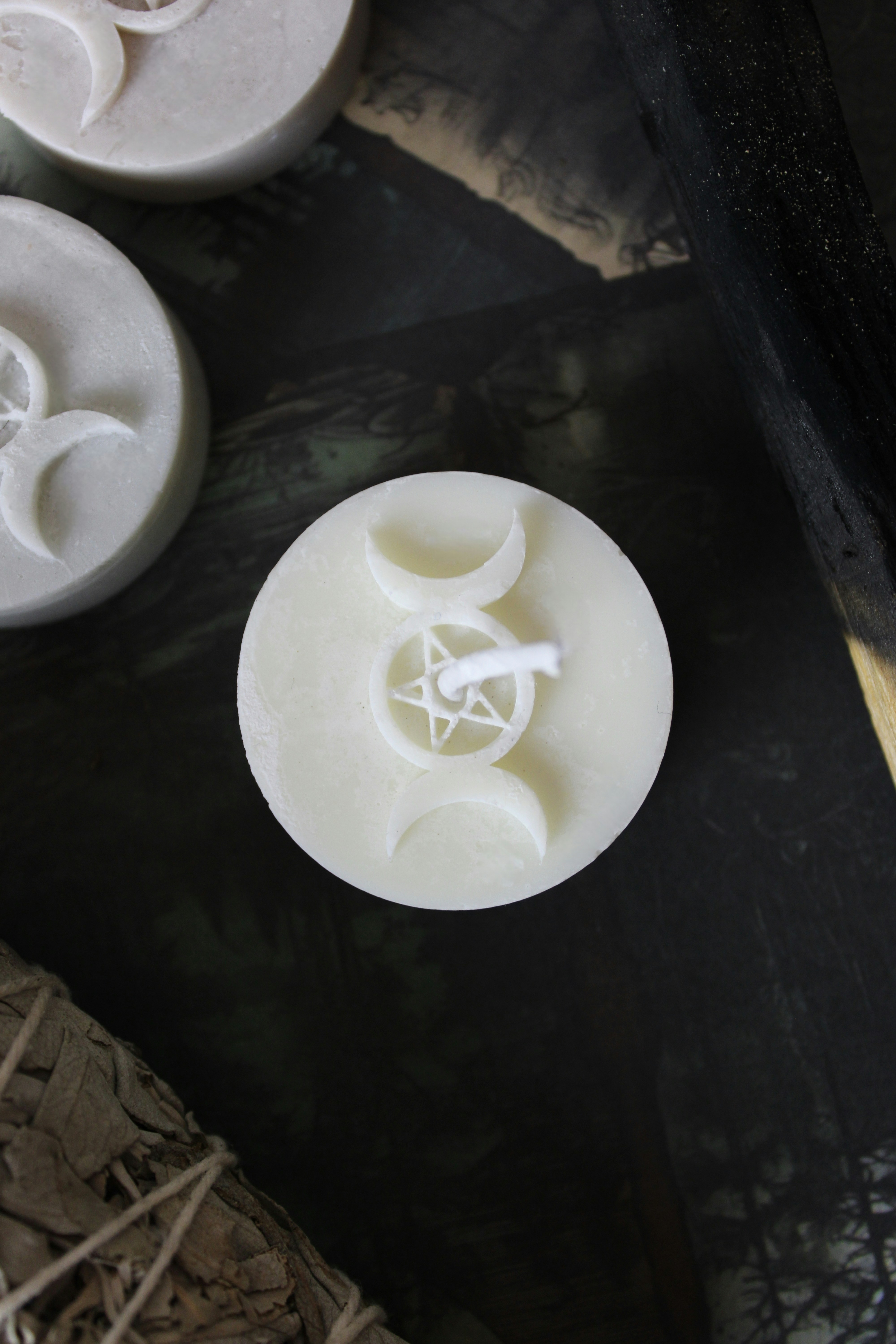 Candles with a triple moon symbol on top.