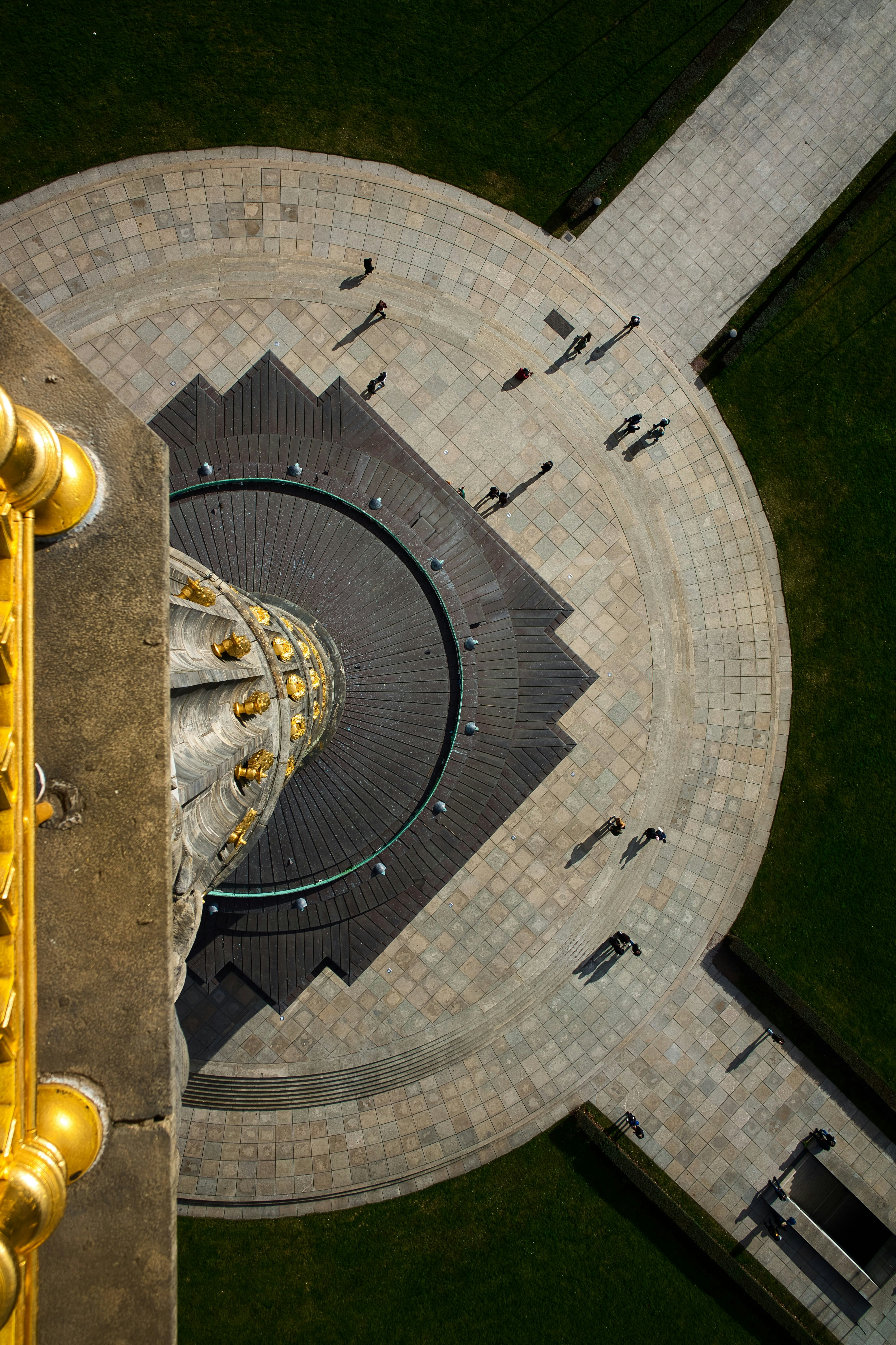 People walk around the base of a tall monument.