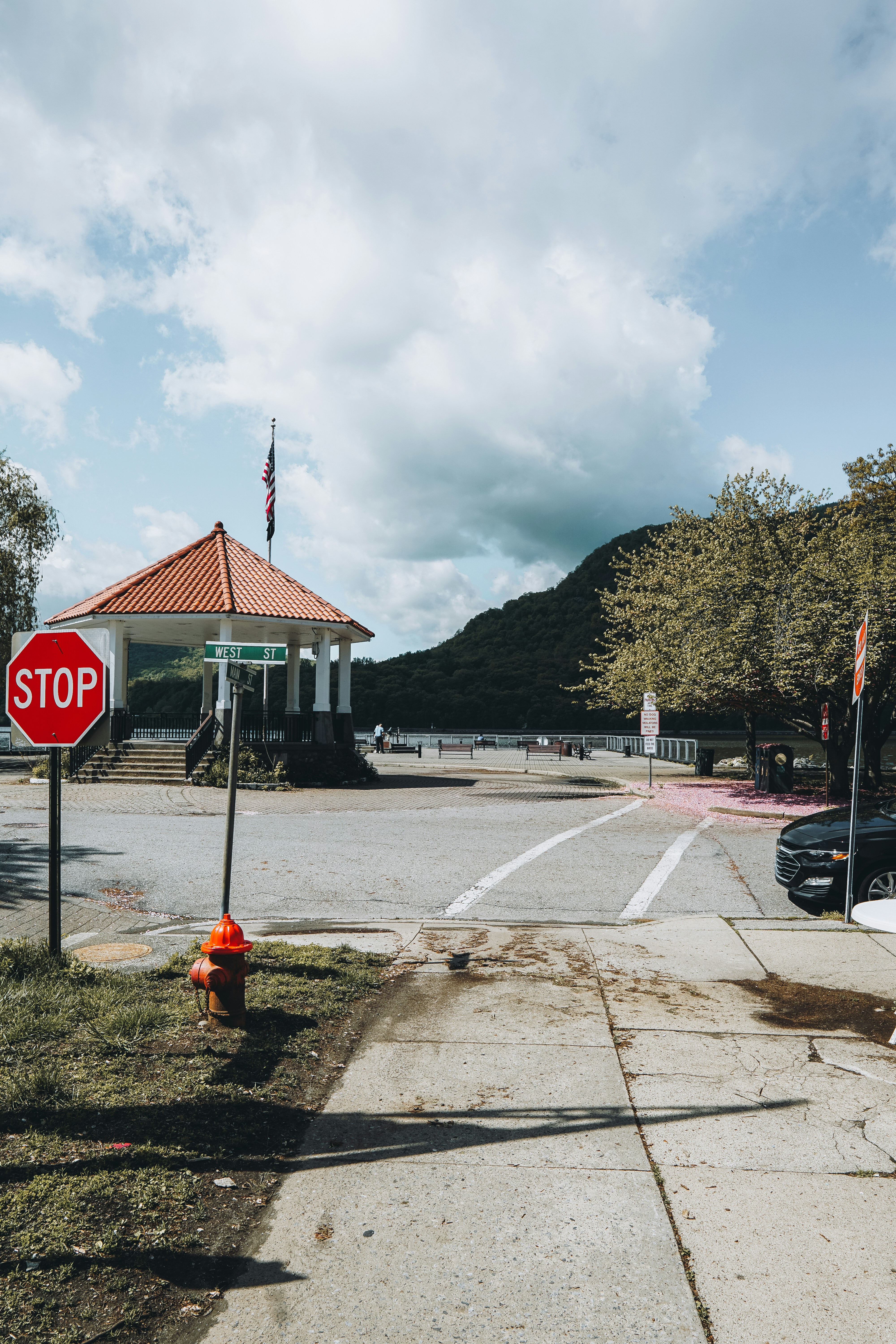 A park entrance with a stop sign and a gazebo.